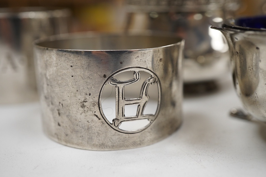 A George V silver three piece condiment set by Walker & Hall, Sheffield, 1921, together withy two other silver condiments, three assorted silver condiment spoons and four assorted silver napkin rings.